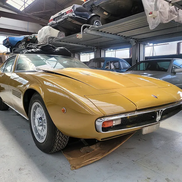 Maserati Ghibli dorée dans un entrepôt de voitures anciennes sur des étagères à Nanterre en Hauts-de-Seine 92