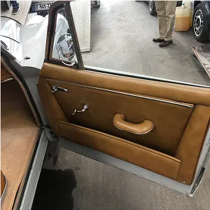 Intérieur d'une porte de voiture vintage en cuir marron avec poignée, vue de l'extérieur à Nanterre en Hauts-de-Seine 92