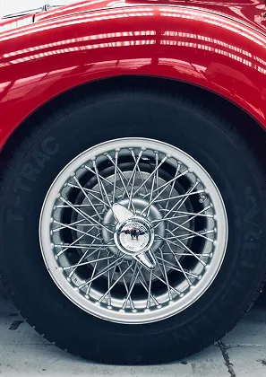 Gros plan d'une roue de voiture classique rouge avec jante à rayons à Nanterre en Hauts-de-Seine 92